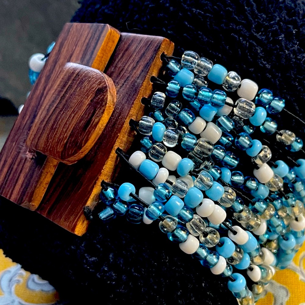 Beautiful beaded cuff bracelet in brown, white, blue, clear and wooden clasp